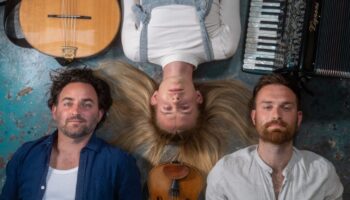 three musicians lying on their backs pictured from above
