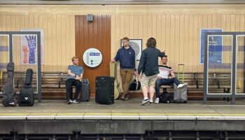 Four bands members at train station
