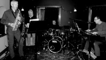 Black and white photo of band in studio.