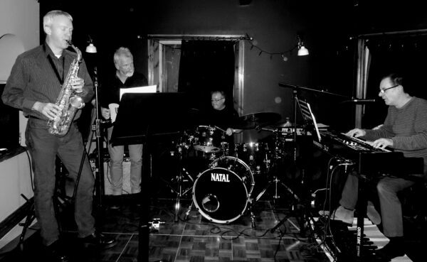 Black and white photo of band in studio.