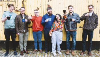 7 band members holding mugs