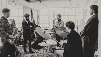 Five musicians playing in a barn