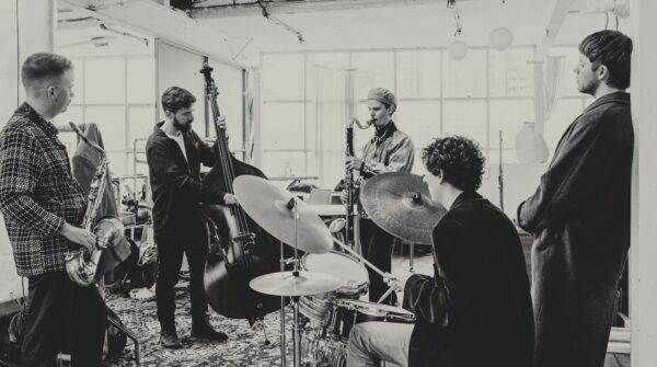 Five musicians playing in a barn