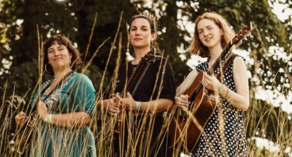 Three female musicians under a tree