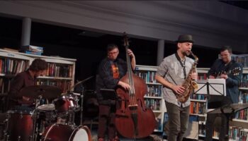four musicians playing in a library