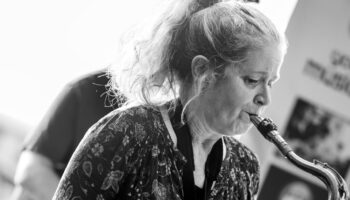 monochrome image of Sue Ferris playing saxophone
