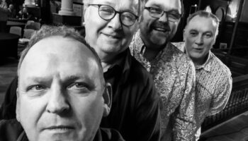 Monochrome selfie of the four musicians